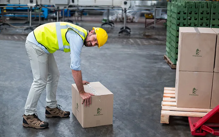 Mann stappelt Kartons aufeinander  Mann stappelt Kartons aufeinander