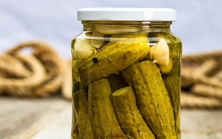 Einwegglas das Essiggurken verpackt