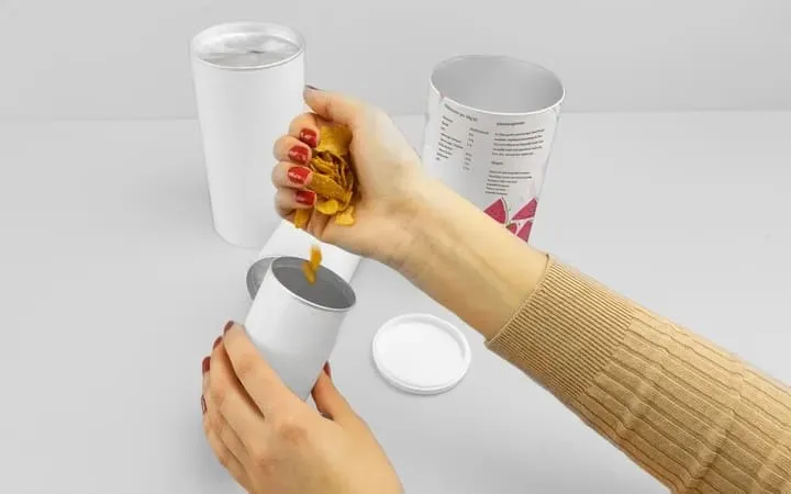 Frau befüllt Papierdose mit Cornflakes Frau befüllt Papierdose mit Cornflakes