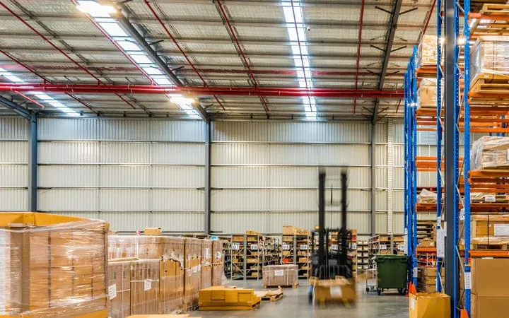 Lagerhalle mit Paletten voller Kartons aus Wellpappe Lagerhalle mit Paletten voller Kartons aus Wellpappe