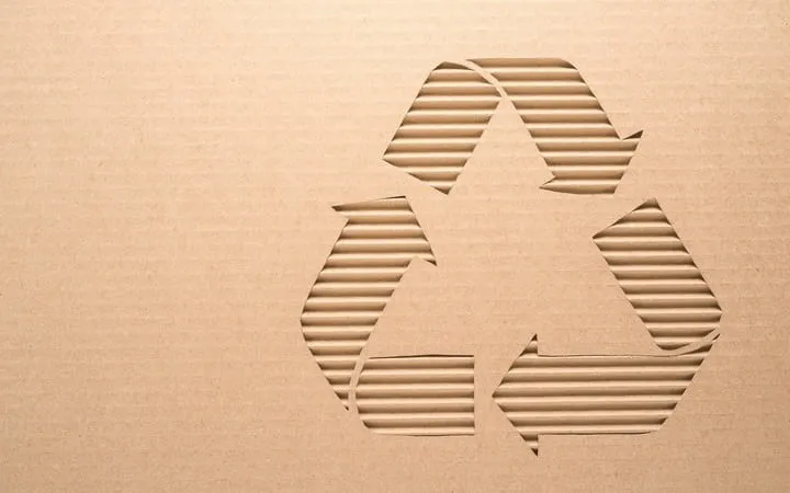 Wellpappe mit Nachhaltigkeitssymbol darauf Wellpappe mit Nachhaltigkeitssymbol darauf