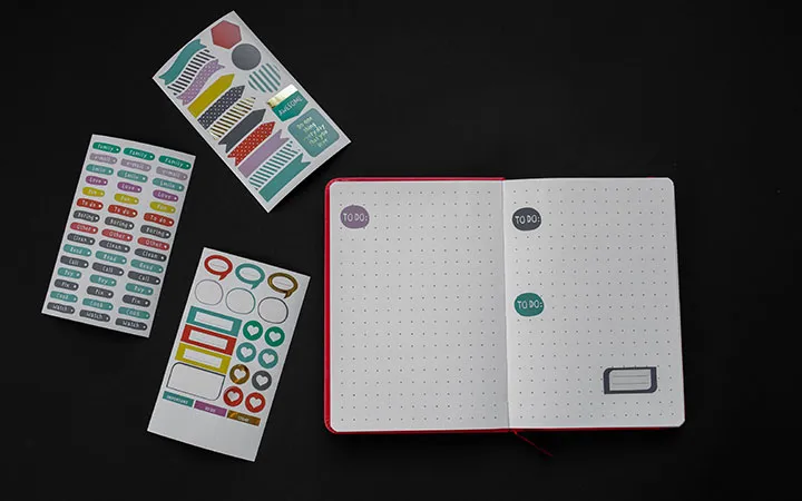 unterschiedliche Bogenetiketten neben Notizbuch unterschiedliche Bogenetiketten neben Notizbuch