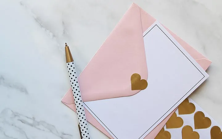 Briefumschlag beklebt mit goldenem Herz-Etikett Briefumschlag beklebt mit goldenem Herz-Etikett