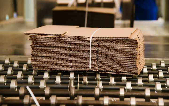 gestapelte Wellpappenkartons eingebunden in Lagerhalle gestapelte Wellpappenkartons eingebunden in Lagerhalle