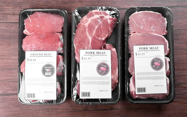 Drei Packungen Rindfleisch mit jeweils einem Etikett auf der Oberfläche mit den Angaben von Preis und Gewicht Drei Packungen Rindfleisch mit jeweils einem Etikett auf der Oberfläche mit den Angaben von Preis und Gewicht